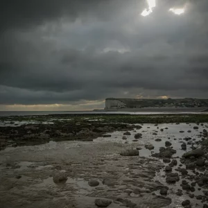 Le soleil parvient à percer entre les nuages sur la plage de Veulettes sur mer.